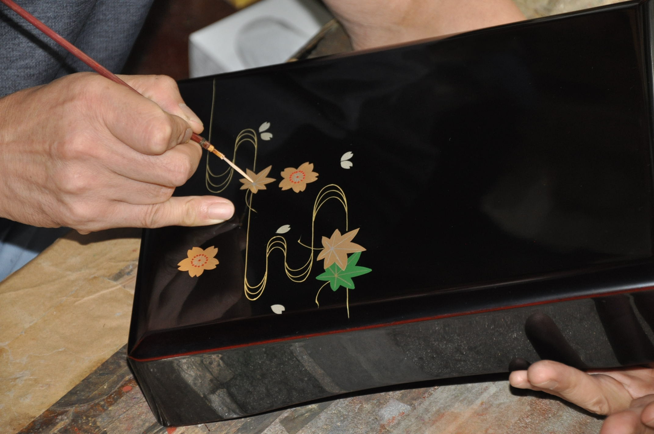 蒔絵を描く職人の手元